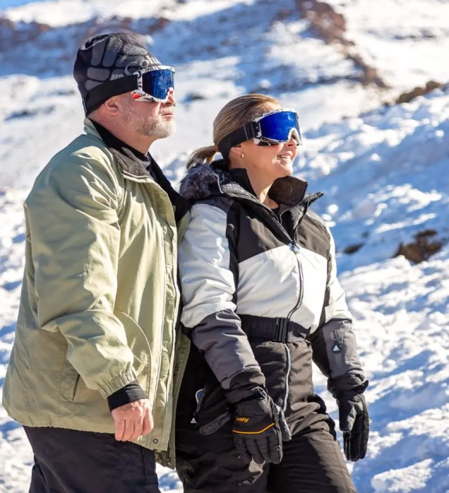 Paar bei einer sonnigen Winterwanderung im Schnee