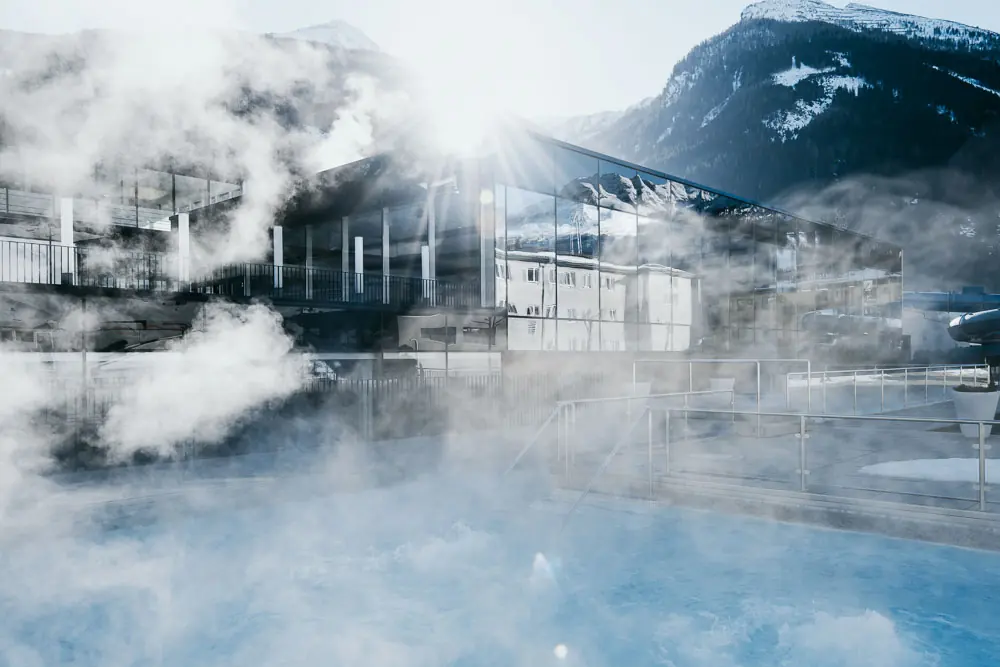 Außenbecken der Felsentherme Bad Gastein vor winterlicher Bergkulisse